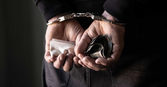 person with handcuffs behind his back