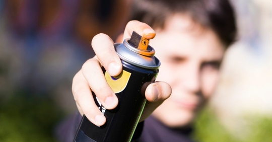 Man holding spray paint can close to camera